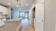 Located at 1880 SW 43rd St in Gainesville, FL, this 2-bedroom, 2-bathroom residence offers a thoughtfully designed single-level layout with modern finishes throughout. The open-concept kitchen and living area serves as the heart of the home, featuring white cabinetry, stainless steel appliances, granite countertops, a central island with pendant lighting, and wood-look flooring that flows seamlessly into the living room. The living room is bright and airy, with a ceiling fan, large windows with blinds, and a glass door that opens to an outdoor area, allowing natural light to fill the space. Both bedrooms are carpeted and equipped with ceiling fans, offering a comfortable retreat. The primary bedroom is generously sized and connects to a full en-suite bathroom featuring granite countertops, white cabinetry, wood-look flooring, and a walk-in closet with wire shelving. The second bathroom mirrors the same quality finishes and includes a tub-shower combination. Each bedroom is complemented by its own walk-in closet with built-in wire shelving for ample storage. The overall design strikes a balance between contemporary style and practical functionality, making for a cohesive and comfortable living environment.