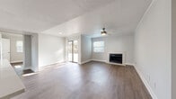 Located on South Lamar Boulevard in Austin's vibrant 78704 zip code, this two-bedroom, two-bathroom residence offers a well-designed single-floor layout with a comfortable and functional living experience. The open living area is a standout, featuring warm wood-style flooring, crown molding, a ceiling fan, and a classic fireplace flanked by a large window and sliding glass door that floods the space with natural light. The sliding door leads directly to a private balcony with a wood-plank deck and metal railing, offering serene, treetop views of the surrounding greenery. The kitchen is thoughtfully appointed with white shaker cabinetry, light quartz countertops, a gray subway tile backsplash, stainless steel appliances, and a double-basin sink beneath a bright window. Both bedrooms feature wood-style flooring, crown molding, and ample natural light, with the primary bedroom offering a walk-in closet with wire shelving. The two bathrooms include tub-shower combinations with clean white surrounds. A dedicated laundry area with a stacked washer and dryer adds everyday convenience. The space is finished in neutral tones throughout, creating a bright, cohesive ambiance.