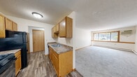 Located at 5641 69th Ave N in Brooklyn Park, Minnesota, this single-floor, 3-bedroom, 1-bathroom home offers a practical and straightforward layout. The open kitchen and living area form the heart of the home, where wood-toned cabinetry, a double sink, and laminate wood-style flooring define the kitchen space. This flows seamlessly into a carpeted living room brightened by a large window with views of the surrounding greenery. Throughout the home, warm oak wood trim frames doorways and windows, adding a cohesive, classic character. Textured ceilings and baseboard heating are consistent features across all rooms. The three bedrooms are carpeted and well-proportioned, with the primary bedroom offering generous space and natural light through multiple windows. Additional bedrooms also feature windows with outdoor views. Closet space is provided by two dedicated closets, one of which includes built-in shelving and hanging rods for organized storage. The bathroom features a clean white vanity with a single-basin sink, brushed nickel fixtures, and mirrored cabinetry. A carpeted hallway connects all rooms, with a wall-mounted intercom unit near the entrance. The overall ambiance is functional and comfortable, suited for everyday living.