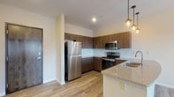 Located at 626 Lehman St in Columbus, Ohio, this single-floor residence offers a thoughtfully designed open-concept layout with contemporary finishes throughout. Light-toned luxury vinyl plank flooring runs through the main living and kitchen areas, creating a cohesive and clean aesthetic.

The kitchen is a standout feature, equipped with rich dark-wood cabinetry, granite countertops, a white subway tile backsplash, and a full suite of stainless steel appliances including a refrigerator, electric range, and over-the-range microwave. A peninsula with an integrated sink and pendant lighting above provides both additional prep space and a casual dining option. The open kitchen flows seamlessly into the spacious living area, which is brightened by recessed lighting and a ceiling fan.

The entry foyer offers closet storage and transitions naturally into the main living space. The bedrooms are carpeted for comfort and each include a ceiling fan and natural light from windows with blinds. The bathroom is well-appointed with a granite-topped vanity featuring dark wood cabinetry, a large mirror, and a full tub-shower combination. Clean, neutral wall tones throughout the unit create a versatile and welcoming atmosphere.