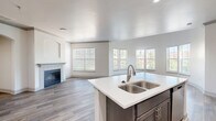 Located at 200 Stetson St in Cincinnati, Ohio, this well-appointed 2-bedroom, 3-bathroom residence offers a thoughtfully designed single-floor layout. The open-concept kitchen and living area serves as the heart of the home, featuring wood-look luxury vinyl flooring, crown molding, and a charming fireplace framed by an arched built-in niche. Large windows with blinds flood the living room with natural light and offer views of the surrounding neighborhood. The kitchen is outfitted with stainless steel appliances, including a range, microwave, and refrigerator, complemented by dark cabinetry, white quartz countertops, and an arched passageway connecting to the living space. The generously sized primary bedroom features plush carpeting, a walk-in closet with wire shelving, and a private en-suite bathroom. The bathrooms are finished with wood-look tile flooring, dark vanity cabinetry, white quartz countertops, and tub-shower combinations. A dedicated laundry room with a washer and overhead shelving adds everyday convenience. Two hallways connect the space efficiently, and two closets provide ample storage throughout. The clean, neutral palette and modern finishes create a bright and welcoming atmosphere throughout.
