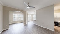 Located at 1150 Baxter Ln in Knightdale, NC, this single-story home offers a thoughtfully designed layout with one bedroom, two full bathrooms, and generous living spaces throughout. The open-concept main living area is highlighted by elegant arched doorways, crown molding, ceiling fans, and neutral-toned walls that create a bright, welcoming ambiance. Durable hardwood-style flooring flows through the living, dining, and kitchen areas, complemented by an abundance of natural light streaming through multiple windows with blinds. The galley-style kitchen is well-appointed with white cabinetry, white quartz countertops, a subway tile backsplash, stainless steel appliances including a refrigerator, range, microwave, and dishwasher, and a window-side sink. The dining area features pendant lighting and connects seamlessly to the main living space. The spacious primary bedroom is carpeted for comfort and includes a ceiling fan and ample natural light. Both bathrooms are finished with wood-look tile flooring, white vanities with quartz countertops, large mirrors, and tiled soaking tub-shower combinations. Additional conveniences include multiple closets, a dedicated laundry area, a utility room, and an entrance foyer, rounding out this well-organized and move-in-ready home.