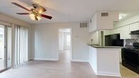 Located at 4711 S Himes Ave in Tampa, FL, this single-floor, one-bedroom, two-bathroom unit offers a practical and well-organized layout. The living room is a bright, open space featuring light wood-look flooring, a ceiling fan with integrated lighting, and a sliding glass door that opens to a private outdoor patio, allowing natural light to flow freely throughout.

The galley-style kitchen is efficiently designed with white cabinetry, dark granite-look countertops, a stainless steel sink, and black appliances including a refrigerator, stove, and dishwasher. A dedicated closet adjacent to the kitchen provides additional storage. The kitchen opens toward the living area via a half-wall breakfast bar.

The spacious primary bedroom accommodates comfortable furnishings and is brightened by two windows with blinds and a ceiling fan overhead. Both bathrooms are clean and functional, featuring white vanity cabinetry, a large mirror with overhead lighting, and a tub-shower combination with tiled surrounds.

Two closets provide ample storage throughout the unit. Neutral wall tones, textured ceilings, and consistent wood-look flooring create a cohesive and easy-to-personalize interior. The unit's efficient use of space makes it a well-suited option in the South Tampa area.
