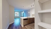 Step into a world of contemporary elegance and effortless living. This stunning 650 square foot apartment is your gateway to a life of convenience and sophistication. The heart of this home is the beautifully appointed kitchen, where gleaming stainless steel appliances and chic two-tone cabinetry create a culinary haven that will inspire your inner chef. Sleek quartz countertops provide ample space for meal preparation and casual dining.

The living area is a testament to modern design, with its expansive feel and abundant natural light streaming through large windows. Plush carpeting in the bedroom and living spaces offers comfort underfoot, while the stylish wood-look flooring in the kitchen and entryway adds a touch of warmth and durability.

The spacious bedroom, measuring an impressive 190 square feet, serves as your personal sanctuary. It boasts ample space for a king-size bed and additional furniture, ensuring you have room to relax and recharge. The bathroom is a model of contemporary design, featuring a large, curved shower enclosure and built-in storage shelves for ultimate convenience.

Throughout the apartment, you'll find thoughtful details that elevate your living experience. Track lighting in the kitchen, recessed lighting in the living areas, and an array of windows create a bright, airy atmosphere that adapts to your mood and the time of day.

This home is more than just a place to live – it's a lifestyle upgrade that puts you at the center of urban excitement while providing a tranquil retreat. Whether you're a young professional, a couple starting out, or someone who appreciates the finer things in life, this apartment offers the perfect canvas to paint your dreams and aspirations. Welcome home to a space that truly reflects your success and style.