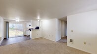 Located at 1248 SW Kiley Way in Beaverton, Oregon, this single-floor, three-bedroom, two-bathroom home offers a practical and comfortable layout. The open-concept living area features neutral carpet flooring that flows into a combined dining and kitchen space. The kitchen is equipped with white cabinetry, a black electric range, black refrigerator, and a raised breakfast bar peninsula that separates it from the living area. Wood-look flooring in the kitchen adds a clean, durable touch. A sliding glass door in the living area leads to a private patio, filling the space with natural light and outdoor views. The bedrooms are carpeted and bright, with windows providing natural light; one features corner windows for added openness. Four closets, including a walk-in with wire shelving, offer generous storage throughout. Both bathrooms include white vanities with granite-style countertops and lighted mirrors. One bathroom features a tub-shower combo with wood-look flooring, while the other opens to the hallway. An in-unit laundry area adds everyday convenience. The home's clean, neutral palette and functional floor plan make it a well-organized and comfortable residence in the Beaverton area.