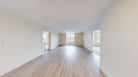 This thoughtfully laid-out 3-bedroom, 2-bathroom residence offers a functional and modern living environment across a single floor. The open living area is finished with light-toned hardwood-style flooring and neutral cream walls, creating a bright and welcoming atmosphere. Large multi-pane windows allow generous natural light to flow throughout the space and offer views of the surrounding urban streetscape.

The kitchen features white shaker-style cabinetry with brushed nickel hardware, crisp white quartz countertops, a classic subway tile backsplash, and stainless steel appliances including a range and built-in microwave — providing a clean, contemporary aesthetic.

The three bedrooms are carpeted in a soft neutral tone, each offering windows that bring in natural light. The spacious primary bedroom provides a comfortable retreat with ample room for furnishings.

Both bathrooms are finished with large-format marble-look porcelain tile surrounding deep soaking bathtubs, complemented by brushed nickel fixtures. The overall design maintains a consistent, polished feel throughout.

The residence combines practical layout with modern finishes, making it a comfortable and functional home with a clean, contemporary character from entry to bedroom.