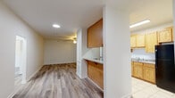 Located at 1214 Bradley Bowen Dr in Remerton, Georgia, this single-floor residence offers a straightforward and functional layout designed for comfortable everyday living. The interior is finished with wood-look laminate flooring throughout the main living areas and bedrooms, lending a clean, cohesive aesthetic across the space.

The living area is open and well-lit, featuring recessed lighting and a ceiling fan that promotes airflow and comfort. It connects seamlessly to the kitchen via a pass-through bar with warm wood-toned cabinetry panels, creating an accessible, semi-open feel between the two spaces. The kitchen itself is equipped with light oak cabinetry offering ample storage, a double-basin sink, a dishwasher, and a full-size refrigerator, all set over durable tile flooring.

The bedrooms are generously proportioned, each outfitted with ceiling fans and wood-look flooring. Several rooms include closets and windows that invite natural light and outdoor views, contributing to a bright and airy atmosphere. The layout also includes a hallway corridor connecting the private areas of the home.

Two full bathrooms serve the residence, each featuring a tub-shower combination, toilet, and tile flooring. The clean white fixtures and neutral wall tones give both bathrooms a tidy, functional appearance. Overall, the home presents a neutral palette throughout, providing a versatile canvas ready for personalization.