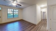 Located in Charlotte's vibrant Dilworth neighborhood, this well-appointed 3-bedroom, 2-bathroom home offers a thoughtfully designed single-floor layout. The open-concept kitchen is a standout feature, showcasing warm wood cabinetry, a dark granite-topped island, subway tile backsplash, stainless steel appliances, and stylish pendant lighting — all flowing seamlessly into a spacious living area with rich hardwood-style flooring throughout. The primary bedroom is generously sized, complete with plush carpeting, a ceiling fan, and direct access to a private en-suite bathroom and a walk-in closet fitted with wire shelving. The additional bedrooms also feature carpet, ceiling fans, and windows that invite natural light. Both bathrooms are finished with granite countertops, warm wood vanities, and tub-shower combinations. A dedicated in-unit laundry room includes a full-size washer and dryer and additional shelving. Three closets provide ample storage throughout the home. A private balcony overlooks a beautifully landscaped courtyard with lush greenery and a pergola structure, offering a serene outdoor retreat. The overall ambiance is clean, modern, and move-in ready.