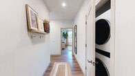 Located in Mesa, AZ, this thoughtfully designed 2-bedroom, 2-bathroom single-floor home offers a comfortable and modern living experience. Warm wood-look flooring flows throughout, tying together a cohesive and inviting aesthetic.

The open-concept kitchen is a standout feature, showcasing taupe shaker cabinetry with black hardware, white subway tile backsplash, quartz countertops, stainless steel appliances, and a central island with pendant lighting — ideal for both everyday living and entertaining. The adjacent living room is bright and airy, with large windows dressed in linen drapes that bathe the space in natural light.

The primary bedroom is generously sized, offering a ceiling fan, hardwood-style flooring, and direct access to a private en-suite bathroom. The en-suite features a dual-sink vanity with white cabinetry and black fixtures, alongside a glass-enclosed walk-in shower with white tile surround. The second bedroom is well-proportioned, bright, and includes dedicated closet space. The second bathroom offers a full tub-shower combo with matching white tile and warm wood-look flooring.

Both bedrooms include dedicated closets, and a hallway connects the rooms efficiently. The overall ambiance is clean, modern, and warmly neutral — ideal for those seeking a move-in-ready home in Mesa.