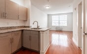 Located at Dock Street in Rahway, NJ, this three-bedroom, two-bathroom residence offers a thoughtfully designed single-floor layout that maximizes functionality. Rich hardwood flooring flows throughout the living areas and bedrooms, lending warmth and cohesion to the space.

The kitchen is a standout feature, outfitted with modern grey cabinetry, granite countertops with a subtle speckled finish, a stainless steel range, built-in microwave, dishwasher, and a peninsula sink that opens toward the living area — creating an inviting, open-concept feel. Track lighting above the kitchen adds a contemporary touch.

Each bedroom is bright and clean, with large windows fitted with horizontal blinds that allow natural light to fill the rooms while offering views of the surrounding neighborhood. Individual wall-mounted HVAC units provide climate control in the bedrooms. The primary bedroom benefits from a dedicated walk-in closet with wire shelving and hanging rods for organized storage.

The two bathrooms are finished with large-format, neutral-toned floor tiles and feature soaking tubs with elegant tile surrounds in a linear pattern and brushed bronze fixtures, conveying a calm, spa-like atmosphere. The overall design is clean and contemporary, ideal for comfortable everyday living.