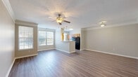 Located at 7160 Oxfordshire Blvd in Noblesville, Indiana, this single-floor, 2-bedroom, 2-bathroom home offers a well-organized and comfortable layout. The open-concept living, dining, and kitchen area forms the heart of the home, featuring durable hardwood-style flooring, crown molding, and a ceiling fan with light fixture. Large windows flood the space with natural light, creating a bright and welcoming atmosphere. The kitchen is designed as a galley-style space with warm wood cabinetry, a double sink, a breakfast bar peninsula, pendant lighting, and black appliances including a refrigerator, range, and dishwasher. The primary bedroom is generously sized, with sliding glass doors that open to an outdoor view, plush carpeting, and access to ample closet space — the home includes six closets in total. The second bedroom also features carpeted flooring and a well-placed window for natural light. Both bathrooms offer wood-toned vanity cabinetry and hardwood-style flooring. A dedicated laundry room adds everyday convenience. The neutral color palette and clean finishes throughout give the home a move-in-ready feel well suited for comfortable living.