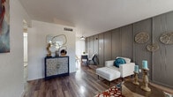 This well-appointed single-floor residence combines contemporary design with functional living across a thoughtfully arranged floor plan. The living area makes a strong first impression with rich hardwood-style flooring, a striking gray shiplap accent wall, and a front door with sidelight panels that invite natural light into the space. The open layout connects the living room seamlessly to a dedicated dining area, creating an inviting flow ideal for both relaxing and entertaining.

The kitchen features two-tone cabinetry — crisp white uppers paired with soft blue-gray lower cabinets — complemented by light quartz countertops, a vertical shiplap-style backsplash, a stainless steel undermount sink, and a stainless steel dishwasher.

The primary bedroom is bright and comfortable, with a large window fitted with white blinds, hardwood-style flooring, and a generously sized sliding-door closet. A second bedroom offers similar flooring, natural light, and dual sliding-door closets, providing ample storage.

Both bathrooms are finished with light quartz vanity tops, gray shaker-style cabinetry, and full tub-shower combinations with clean white tile surrounds. Consistent hardwood-style flooring runs throughout the home, tying each space together with a cohesive, modern aesthetic.
