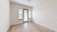 This contemporary 680 square foot apartment offers a thoughtful blend of style and functionality. The open-concept layout seamlessly integrates the kitchen, living, and dining areas, creating a spacious feel. The gourmet kitchen is a standout feature, boasting dark wood cabinetry, stainless steel appliances, and a large island with a sleek countertop, perfect for meal prep or casual dining. Pendant lighting adds a touch of sophistication.

The living area is bright and airy, with wood-look flooring and ample natural light streaming through large windows. The bedroom, measuring 150 square feet, features plush carpeting and a ceiling fan for comfort. The bathroom showcases a modern vanity with a marble-like countertop and connects directly to the in-unit laundry area, equipped with full-sized washer and dryer.

Throughout the apartment, neutral tones create a calming atmosphere, while strategic lighting enhances the overall ambiance. The efficient design maximizes every inch of the 680 square feet, offering both style and practicality for modern living.