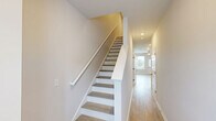 Located at 7405 Fletcher Drive in Chattanooga, Tennessee, this two-story home offers three bedrooms and three bathrooms across two well-proportioned floors. The main level provides a bright, open living area with light hardwood-style flooring, a ceiling fan, and multiple windows that fill the space with natural light and views of the surrounding neighborhood. The kitchen is a standout feature, showcasing sleek gray cabinetry with gold-tone hardware, white quartz countertops, stainless steel appliances, and a central island — ideal for both cooking and entertaining. A half bath on the main level adds convenience, and an attached garage with an automatic opener completes the ground floor. Upstairs, the generously sized primary bedroom features a tray ceiling, ceiling fan, and a walk-in closet with built-in wire shelving. Two additional bedrooms share the upper level, each with light flooring and windows overlooking the outdoors. The bathrooms are clean and functional, with one featuring a full tub-shower combination. Hallways connect each floor efficiently, and a dedicated closet provides additional storage. The home's neutral palette and consistent light flooring throughout create a cohesive, move-in-ready aesthetic.