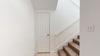 This two-story home in Taylor, TX offers a practical and well-organized layout across two levels. The ground floor provides direct access to an attached garage equipped with an automatic opener, alongside a welcoming entrance with tile flooring and carpeted stairs leading to the main living level above. The upper floor hosts the majority of the living space, where an open-concept kitchen and living room serve as the heart of the home. The kitchen features light wood cabinetry with warm trim accents, a double sink, electric range, built-in microwave, and a dishwasher, all set on durable light wood-look flooring. An arched window in the adjoining living area brings in natural light, creating a bright and airy atmosphere. Both bedrooms are carpeted and finished with crisp white walls, offering comfortable and versatile spaces. The primary bedroom is generously sized and provides ample room for furnishings. A hallway connects the upper-level rooms, with built-in closet storage visible in one of the secondary spaces. The two bathrooms include light wood vanity cabinetry, white countertops, large mirrors, and tub-shower combinations with tile surrounds, all accented by light wood-look flooring. The home presents a clean, neutral aesthetic throughout, making it move-in ready.