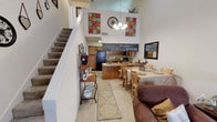 Located at 9137 Mansfield Rd in Shreveport, Louisiana, this two-story residence offers a thoughtfully designed layout that combines open living spaces with functional private areas across both floors. The main level makes an immediate impression with its dramatic vaulted ceilings and a skylight that floods the living area with natural light. A classic fireplace with a tiled hearth serves as a focal point in the living room, which flows seamlessly into the dining area and kitchen. The kitchen is equipped with warm wood cabinetry, black appliances including a refrigerator, range, and built-in microwave, and durable tile flooring. A staircase with carpeted treads leads to the upper level, where a loft-style overlook adds architectural depth to the open-concept main floor. The bedrooms are generously proportioned, carpeted for comfort, and feature ceiling fans and ample natural light from well-placed windows. Each bedroom is served by a full bathroom featuring wide vanities with under-sink cabinetry and large mirrors. The bathrooms include a combination tub and shower, as well as a separate water closet configuration in one. Throughout, the home maintains a neutral, welcoming palette that highlights its spacious and airy character.