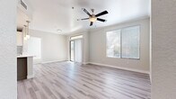 This well-appointed single-floor residence offers a clean, contemporary design throughout. The open living area is bathed in natural light, courtesy of a sliding glass door leading to a private balcony and large windows dressed with horizontal blinds. Light wood-style luxury vinyl plank flooring flows seamlessly through the main living spaces, complemented by neutral-toned walls and crown molding. A ceiling fan adds both function and style to the living area.

The kitchen is outfitted with stainless steel appliances — including a range and over-the-range microwave — paired with white upper cabinetry and gray lower cabinets atop light countertops, creating a crisp, modern aesthetic.

The bedrooms feature plush carpeting and receive ample natural light through windows with blinds. A generously sized walk-in closet offers extensive built-in shelving and hanging rods, providing abundant storage. The bathroom presents a refined finish with a granite-style countertop, undermount sink, gray shaker-style vanity cabinetry, brushed nickel fixtures, and a large framed mirror.

A dedicated laundry area conveniently houses a full-size washer and dryer. The light wood-style flooring in the utility hall maintains design continuity throughout the home, creating a cohesive and polished living environment.