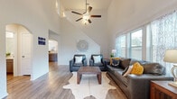 Located at 14004 Grover Creek Dr in Conroe, Texas, this two-story home offers a thoughtfully designed layout with a warm, modern aesthetic throughout. The entryway sets an inviting tone, welcoming guests with clean lines and wood-look flooring that flows seamlessly through the main living areas. The living room is a standout space, boasting soaring vaulted ceilings, a ceiling fan, and ample natural light streaming in through large windows, creating an airy and open atmosphere. Elegant arched doorways add a classic architectural touch that carries through the home. The kitchen features rich cabinetry, light stone-toned countertops, and a double sink, opening toward a dedicated dining area complete with a chandelier and generous seating—ideal for gatherings. A dedicated home office provides a bright, functional workspace with a window for natural light. The primary bedroom is generously sized with ceiling fan, large windows, and connects to an en-suite bathroom with granite-style countertops and ample vanity space, as well as a spacious walk-in closet with built-in shelving and hanging rods. Additional bedrooms offer comfortable accommodations with neutral tones and wood-look flooring. Bathrooms throughout maintain a clean, bright finish with tile flooring. This home combines practical design with inviting details across both floors.