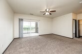 Located at 4408 Ashworth Dr in Cedar Falls, Iowa, this 2-bedroom, 1-bathroom residence offers a thoughtfully designed single-floor layout with a clean, modern aesthetic. The open-concept living and dining area features plush carpeting, a ceiling fan with light, and sliding glass doors that lead to a private balcony with outdoor views — filling the space with natural light. The kitchen is well-appointed with rich dark cabinetry, light granite-style countertops, a breakfast bar peninsula, wood-look flooring, and a full suite of black appliances including a refrigerator, range, and dishwasher. Both bedrooms are carpeted and bright, each with windows overlooking the surrounding neighborhood and landscape. The primary bedroom is a comfortable size, accompanied by its own closet, while the second bedroom also features dedicated closet storage. The full bathroom includes a tub/shower combination and wood-look flooring. Additional practical features include an in-unit laundry area, a utility room, and four closets throughout for ample storage. Dark-trimmed doors and baseboards provide a consistent, polished design element throughout the entire residence.