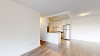 Located at 9304 Salish Court in Burnaby, BC, this well-appointed two-bedroom, one-bathroom residence offers a thoughtfully designed single-floor layout. The open-concept living and dining area is bathed in natural light, showcasing light wood-tone laminate flooring and clean white walls that create a bright, airy atmosphere. Large floor-to-ceiling sliding glass doors lead to a private balcony, framing views of surrounding greenery and the neighbouring Burnaby skyline.

The galley-style kitchen is efficiently designed with white cabinetry, subway tile backsplash, dark countertops, and a full suite of stainless steel appliances including a refrigerator, dishwasher, and electric range. Tile flooring in the kitchen provides a practical transition from the main living areas.

The spacious primary bedroom features mirrored sliding closet doors and hardwood-style flooring, while the second bedroom offers similar finishes and storage. The bathroom is finished with subway tile walls, a modern floating vanity with an undermount sink, and sleek hardware. Five closets throughout the unit provide ample storage. The layout flows naturally through two hallways, connecting all rooms with ease.