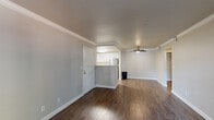 Located at 4949 Snyder Ln in Rohnert Park, CA, this well-appointed one-bedroom, one-bathroom unit offers a thoughtfully designed single-floor layout. The open-concept living and kitchen area serves as the heart of the home, finished with rich dark hardwood-style flooring and accented by crisp crown molding throughout. A ceiling fan adds comfort to the living space, while a sliding glass door opens to a private patio that overlooks a landscaped setting framed by towering mature trees.

The kitchen is outfitted with white shaker cabinetry, a peninsula counter, and a full suite of stainless steel appliances including a refrigerator, range, and microwave. A dedicated entry door provides a clear separation between the living area and the rest of the unit.

The bedroom offers a comfortable and quiet retreat, featuring plush wall-to-wall carpeting, a window with blinds that brings in natural light, and direct access to a dedicated closet. The bathroom includes a full tub and shower combination with clean, bright finishes.

A hallway connects the rooms cohesively, and the overall neutral color palette creates a calm, move-in-ready ambiance throughout the unit.