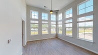 Located on Manhattan Blvd in Dayton, Kentucky, this single-floor residence offers a thoughtfully designed layout that balances openness with functional living spaces. The most striking feature is the expansive main living area, where soaring double-height ceilings meet floor-to-ceiling windows arranged across two walls. This dramatic windowed corner floods the room with abundant natural light and frames sweeping outdoor views, while a ceiling fan provides comfort overhead. Light-toned wood-style flooring runs throughout the main living areas, enhancing the airy, open feel. The kitchen is well-equipped with white shaker cabinetry, a classic subway tile backsplash, stainless steel appliances including a refrigerator, range, and microwave, and a large center island with quartz countertops and an undermount sink. Pendant and track lighting complete the kitchen's modern aesthetic. The bedrooms offer plush carpet flooring and natural light through double windows, with at least one bedroom featuring a spacious walk-in closet with built-in shelving. The bathrooms are finished with quartz vanity countertops, wood-style flooring, and tiled tub-shower combinations. Clean, neutral tones throughout create a cohesive and move-in-ready environment suited for comfortable everyday living.