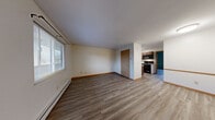 Located at 1840 Garden Ridge Drive in Toledo, Ohio, this one-bedroom, one-bathroom unit offers a practical and well-organized single-floor layout. The open-concept living, dining, and kitchen area creates a cohesive central space, with light-toned hardwood-style vinyl flooring running throughout. Natural light filters in through horizontal-blind-fitted windows, and baseboard heating ensures year-round comfort.

The kitchen is efficiently designed with warm medium-toned wood cabinetry, light countertops, a double sink, a black electric range and over-the-range microwave, and a full-size refrigerator — providing ample functionality within a compact footprint. A half-wall partition subtly separates the kitchen from the living and dining area, maintaining an open feel.

The bedroom features soft sage-green walls, a wall-unit air conditioner, a closet, and a window overlooking the outdoors. An additional closet off the main living area provides extra storage. The full bathroom is finished with teal-accented walls and includes a white soaking tub with a combination showerhead and built-in shelving.

Throughout the unit, warm wood-toned trim and doors provide visual continuity, while the neutral palette offers a clean, move-in-ready aesthetic ideal for comfortable everyday living.