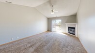Located at 2901 Fletcher Ave in Lincoln, Nebraska, this single-floor, 3-bedroom, 2-bathroom home offers a well-organized layout with comfortable living spaces throughout. The living room is a standout feature, boasting vaulted ceilings, a ceiling fan, a fireplace with a clean white surround, and a sliding glass door that invites natural light and outdoor access. Soft carpeting flows throughout the main living and bedroom areas, adding warmth to the neutral gray and white color palette. The kitchen features white cabinetry with wood-toned accents, white appliances, a sink, and light vinyl plank flooring, with an open connection to the living area for easy flow. The primary bedroom is generously sized, with a ceiling fan, natural light from a window, and access to a spacious walk-in closet fitted with dual hanging rods and shelving on both sides. Additional bedrooms offer carpet flooring and closet access. The bathrooms feature light wood-look vinyl flooring, neutral walls, and functional fixtures. A dedicated laundry room houses a washer and includes an electrical panel for added convenience. With four closets total, storage is plentiful throughout this practical and well-appointed home.