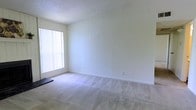 This single-floor space presents a clean, minimalist layout designed to maximize comfort and functionality. The interior is finished with soft, neutral-toned wall-to-wall carpeting that adds warmth underfoot and contributes to the overall understated aesthetic of the space. The walls are painted in a crisp, light tone that enhances the sense of openness and airiness throughout.

A standout feature of the main living area is the large window fitted with vertical blinds, which allows an abundance of natural light to filter into the room while offering privacy control. The generous amount of light flooding the space creates a bright and welcoming atmosphere. The textured ceiling adds a subtle architectural detail that complements the otherwise simple, clean interior design.

The layout is open and versatile, providing ample room for various furniture configurations to suit different lifestyle needs. Neutral finishes throughout ensure the space can be easily personalized. The overall ambiance is calm and functional, making it well-suited as a comfortable living environment. The single-floor design offers convenient accessibility and a straightforward flow throughout the space.