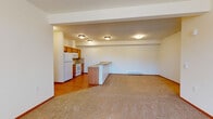 Located at 5317 South Palouse in Spokane, WA, this single-floor unit offers a well-organized, open layout designed for comfortable everyday living. The kitchen is fully equipped with warm honey-toned wood cabinetry, a tile backsplash, a full suite of white appliances including a refrigerator, electric range, built-in microwave, and dishwasher, along with durable countertops and hardwood-style flooring. A peninsula counter extends into the living area, creating a natural divide between the kitchen and the spacious carpeted living room. The open-concept design allows for generous flow between these areas, with baseboard heating units throughout. A sliding glass door in the living room brings in natural light and provides outdoor access. The bedrooms are carpeted and feature large windows that invite in daylight and offer pleasant outdoor views of surrounding greenery. The bathrooms are finished with tile flooring, a wood-toned vanity with countertop storage, and a full bathtub and shower combination. Safety grab bars are present in one of the bathrooms. The unit's neutral color palette, consistent warm wood accents, and efficient single-floor plan make it a practical and welcoming space.