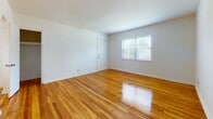 Located at 502 Grantham Road in Norfolk, Virginia, this single-floor home presents a clean, straightforward layout with consistent design details throughout. Rich, warm-toned hardwood floors run continuously through the living areas and bedrooms, lending a cohesive and inviting character to the space. Crisp white walls and white trim complement the natural wood tones and help maximize the sense of light and openness in each room.

The living area benefits from a large window that allows natural light to fill the space, while multiple bedroom-sized rooms offer flexibility in use. One room features built-in wall shelving with decorative scalloped edging, adding a charming architectural detail. Several rooms are equipped with ceiling vents for climate control, and textured ceilings are present in portions of the home.

The kitchen is well-equipped with warm oak cabinetry, ample upper and lower storage, dark countertops, a double-basin sink, and white appliances including a range and refrigerator. A window above the counter provides natural light and views to the exterior. The bathroom includes a full-size soaking tub with a shower rod, a toilet, and tile flooring, with a window providing natural ventilation. Throughout, the home maintains a neutral, functional aesthetic well-suited for comfortable everyday living.