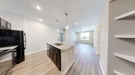 Located in Dallas, TX, this single-story 2-bedroom, 2-bathroom home offers a thoughtfully designed open-concept layout that seamlessly connects the kitchen, dining, and living areas. Light wood-tone luxury vinyl plank flooring runs throughout the main living spaces, complemented by crisp white walls and recessed lighting that create a bright, contemporary ambiance.

The kitchen is a standout feature, showcasing dark espresso cabinetry with brushed nickel hardware, granite countertops, a central island with a single-basin sink, and stylish pendant lighting. A set of built-in open corner shelves adds additional display and storage space. Dark appliances complete the kitchen's bold, modern aesthetic.

The living area is generously proportioned, with a ceiling fan and a large window that invites natural light and outdoor views. The primary bedroom continues this airy feel, offering dual windows, a ceiling fan, and a private exterior door. Both bathrooms are finished with large-format tile flooring, dark vanity cabinetry, granite countertops, and framed mirrors.

Additional highlights include three closets, a dedicated laundry area, and a defined entrance. The layout is efficient and functional, making excellent use of the available space throughout.