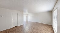 This single-story, 3-bedroom, 2-bathroom home in Baton Rouge, Louisiana offers a practical and comfortable layout. Throughout the main living areas, wood-look flooring adds warmth and cohesion, while textured ceilings lend a classic residential character. The living room is bright and open, featuring a large window with blinds that invites natural light and provides a welcoming atmosphere. Adjacent to the living room, the dining area is highlighted by a brass chandelier and a sliding glass door flanked by vertical blinds, opening to the outdoors. The kitchen is efficiently laid out in an L-shape, featuring white cabinetry, light countertops, a double-basin stainless steel sink, and a dishwasher — offering ample storage and workspace. The three bedrooms are carpeted for comfort, with neutral walls and windows that bring in natural light; the primary bedroom provides a generous, functional footprint. The two bathrooms include a full bath with a tub-shower combination and a half bath equipped with a vanity, mirrored medicine cabinet, and a towel bar. The home's clean, neutral palette throughout creates a versatile canvas for personalization.