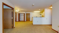 Located at 3953 S Prairie Hill Ln in Greenfield, Wisconsin, this single-floor unit offers a practical and comfortable layout designed for easy living. The open living area is finished with warm carpeting and neutral walls, creating a welcoming atmosphere throughout. A ceiling fan provides comfort and light, while a baseboard heating system ensures warmth during Wisconsin winters.

The kitchen is thoughtfully designed with white cabinetry offering ample storage, a full suite of appliances including a refrigerator and electric range, and a pass-through counter that opens to the main living space — ideal for both everyday use and entertaining. The tile flooring in the kitchen adds a clean, durable touch.

The bedrooms are carpeted for comfort and each features a ceiling fan and natural light from windows fitted with blinds. Generous closet space is available, with an open-rack walk-in closet visible off the main living area.

The bathroom is well-appointed with tile flooring, a vanity with storage, and a tub/shower combination. Throughout the unit, warm wood-toned door trim and baseboards provide a cohesive design detail. The layout flows efficiently, making this a functional and move-in-ready space in a residential Greenfield neighborhood.