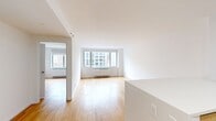 This 550 square foot apartment in New York City offers a well-designed living space with modern amenities. The open-plan layout maximizes the available area, combining the kitchen and living room into one cohesive space. The kitchen boasts stainless steel appliances, including a refrigerator, stove, and over-the-range microwave. Light wood cabinetry and white countertops create a clean, contemporary aesthetic.

The 160 square foot bedroom provides ample space and features a built-in closet with wooden shelving and drawers for efficient storage. Large windows in both the living area and bedroom flood the apartment with natural light and offer impressive views of the surrounding cityscape.

The bathroom is outfitted with modern fixtures, including a vanity with wood cabinetry, a white sink, and a combination bathtub and shower. Neutral-toned tiles and a mirrored medicine cabinet complete the space.

Throughout the apartment, hardwood floors in a warm honey hue add warmth and character. The crisp white walls and recessed lighting contribute to the overall bright and airy ambiance. This efficiently designed one-bedroom apartment maximizes every square foot, providing a comfortable and stylish living space in the heart of New York City.
