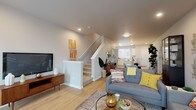 Located at 605 Ayers Rd in Eugene, Oregon, this two-story home offers a thoughtfully designed layout that balances functionality and contemporary style. The main floor features an open-concept living, dining, and kitchen area unified by light wood-tone flooring throughout. The living room provides a comfortable, well-lit gathering space with recessed lighting and easy staircase access to the upper level.

The kitchen is a standout feature, equipped with white shaker cabinetry, stainless steel appliances including a refrigerator, range, microwave, and dishwasher, and a light quartz countertop island with bar seating. A large window allows natural light to fill the space, while a separate dining area sits adjacent to the kitchen for convenient everyday living.

Upstairs, the bedrooms are carpeted for comfort and feature windows that bring in natural light and views of the surrounding greenery. The bathroom includes a wide vanity with white cabinetry and quartz counters, wood-look flooring, and a soaking tub with shower. Neutral tones and clean finishes throughout give the home a modern, move-in-ready appeal.
