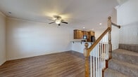 Located at 601 SW Fifth St in Bentonville, Arkansas, this two-story home offers a well-organized layout with functional living spaces across both levels. The main floor features an open living area with rich hardwood-style flooring, crown molding, and a ceiling fan, flowing seamlessly into a kitchen equipped with warm oak cabinetry, granite-style countertops, a breakfast bar, tile flooring, and black appliances including a refrigerator, range, and built-in microwave. A dedicated laundry room with overhead cabinetry and full-size washer and dryer hookups adds everyday convenience. The attached garage provides additional utility space with a concrete floor and interior access door. Upstairs, carpeted bedrooms offer ceiling fans and natural light through slatted blinds. The primary suite includes a spacious walk-in closet with built-in shelving and hanging rods, as well as an en-suite bathroom featuring tile flooring, a separate glass-enclosed shower, a soaking tub, and a wood-vanity with granite-style countertop. Additional bedrooms feature standard closets. A carpeted staircase with classic oak railings and white balusters connects both floors, adding a traditional architectural touch throughout the home.