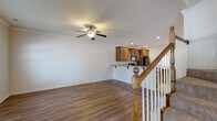 Located at 601 SW Fifth St in Bentonville, Arkansas, this two-story home offers a well-organized layout with functional living spaces across both levels. The main floor features an open living area with rich hardwood-style flooring, crown molding, and a ceiling fan, flowing seamlessly into a kitchen equipped with warm oak cabinetry, granite-style countertops, a breakfast bar, tile flooring, and black appliances including a refrigerator, range, and built-in microwave. A dedicated laundry room with overhead cabinetry and full-size washer and dryer hookups adds everyday convenience. The attached garage provides additional utility space with a concrete floor and interior access door. Upstairs, carpeted bedrooms offer ceiling fans and natural light through slatted blinds. The primary suite includes a spacious walk-in closet with built-in shelving and hanging rods, as well as an en-suite bathroom featuring tile flooring, a separate glass-enclosed shower, a soaking tub, and a wood-vanity with granite-style countertop. Additional bedrooms feature standard closets. A carpeted staircase with classic oak railings and white balusters connects both floors, adding a traditional architectural touch throughout the home.