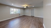 Located at 11441 216th St in Lakewood, California, this single-floor unit offers a clean, modern aesthetic throughout. The open living area is highlighted by durable wood-look flooring, recessed lighting, a ceiling fan, and a wall-mounted AC unit, creating a comfortable and well-lit environment. A large window invites natural light and provides views of the surrounding greenery, enhancing the airy feel of the space.

The kitchen is efficiently designed with white shaker-style cabinetry, granite countertops, a double-basin stainless steel sink, and a full suite of stainless steel appliances including a range, microwave, and refrigerator. The layout flows seamlessly into an adjacent dining or living area, also featuring wood-look flooring and a window with vertical blinds.

The unit includes two bathrooms, both finished with consistent granite vanity countertops, white cabinetry, and wood-look flooring. One bathroom features a tub/shower combination with built-in shelving, while the other is appointed as a half bath. The neutral color palette and clean finishes throughout give the space a fresh, move-in-ready appeal.

The dollhouse view reveals a practical, well-organized floor plan that maximizes the available space efficiently across its single level.