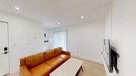 Located at 2715 Dwight Way in Berkeley, CA, this modern single-floor unit offers three bedrooms, one bathroom, and a shared living room within a compact, efficiently designed floor plan. Throughout the space, light wood flooring and crisp white walls create a clean, contemporary aesthetic that feels bright and welcoming.

The living room serves as the central gathering space, featuring recessed lighting, a wall-mounted TV, and a sliding glass door that opens to an outdoor balcony with neighborhood views. Natural light flows freely into the room, enhancing its open feel.

The primary bedroom is generously sized and includes warm wood-toned wardrobe storage and recessed lighting. The two additional bedrooms are thoughtfully laid out — one features a window with natural light, a wardrobe, and a built-in desk area, while the other opens directly to a private balcony. Each bedroom benefits from the same light flooring and neutral palette found throughout the unit.

The bathroom is finished in a clean, modern style with white tile surrounding a full bathtub and shower, dark matte hardware accents, a white vanity with stone-look countertop, and light wood flooring that ties into the rest of the home.

Overall, this unit offers a functional and well-appointed layout well-suited for shared living in the heart of Berkeley.