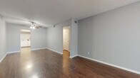 Located at 301 Seacrest Dr in Largo, Florida, this single-floor, 2-bedroom, 2-bathroom residence offers a practical and comfortable layout. The living room is a welcoming, open space highlighted by rich dark hardwood-style flooring, neutral gray walls, a textured ceiling, and a ceiling fan overhead. A large sliding window floods the room with natural light and provides a view of the outdoors, while a dedicated entry door adds convenience.

The kitchen features white cabinetry with ample storage, light countertops, and a full suite of appliances including an electric range, dishwasher, and sink — all set atop matching hardwood-style flooring that continues the cohesive aesthetic. A utility area with laundry hookups and additional cabinetry adds practical functionality.

Both bedrooms are finished with plush carpet flooring and ceiling fans, offering a cozy retreat. The primary bedroom includes access to a dedicated closet. The two bathrooms are finished with tile flooring and white vanities; one includes a full tub-shower combination, while the second serves as a functional half-style bath. Neutral gray tones throughout the home create a clean, move-in-ready atmosphere well-suited to the sunny Largo, FL lifestyle.