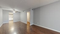 Located at 301 Seacrest Dr in Largo, Florida, this single-floor, 2-bedroom, 2-bathroom residence offers a practical and comfortable layout. The living room is a welcoming, open space highlighted by rich dark hardwood-style flooring, neutral gray walls, a textured ceiling, and a ceiling fan overhead. A large sliding window floods the room with natural light and provides a view of the outdoors, while a dedicated entry door adds convenience.

The kitchen features white cabinetry with ample storage, light countertops, and a full suite of appliances including an electric range, dishwasher, and sink — all set atop matching hardwood-style flooring that continues the cohesive aesthetic. A utility area with laundry hookups and additional cabinetry adds practical functionality.

Both bedrooms are finished with plush carpet flooring and ceiling fans, offering a cozy retreat. The primary bedroom includes access to a dedicated closet. The two bathrooms are finished with tile flooring and white vanities; one includes a full tub-shower combination, while the second serves as a functional half-style bath. Neutral gray tones throughout the home create a clean, move-in-ready atmosphere well-suited to the sunny Largo, FL lifestyle.
