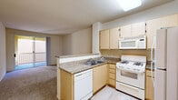 Located at 4800 Tassajara Rd in Dublin, CA, this one-bedroom, one-bathroom residence offers a practical and well-organized single-floor layout. The kitchen serves as a central feature, equipped with light wood cabinetry, granite-style countertops, a gas range, dishwasher, refrigerator, and built-in microwave. A skylight overhead brightens the space, while a peninsula counter seamlessly connects the kitchen to the carpeted living area. Sliding glass doors in the living room open to a private balcony, allowing natural light to flow into the shared space. The bedroom is comfortably sized, featuring plush carpeting, a window with vertical blinds that filter natural light, and access to an adjacent closet. A hallway with an arched architectural detail connects the main living areas to the bathroom, which includes a full-size soaking tub and shower combination with tile surround and polished chrome fixtures. Neutral tones throughout the unit — including beige walls, light wood finishes, and warm carpeting — create a cohesive and understated aesthetic. The layout is thoughtfully designed to maximize functionality within a compact footprint, making it a practical option in the Dublin, CA area.