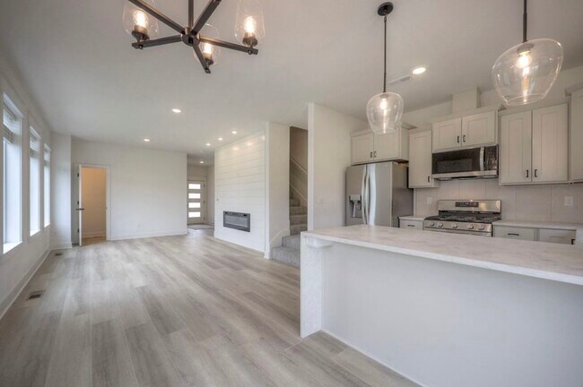 Espacio de estar abierto y luminoso con chimenea eléctrica y luz natural - 22907 W 72nd Ter