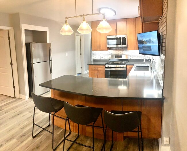 Built in refrigerator, three counter height chairs included. - 771 56th St Apartments