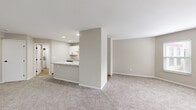 Located at 399 S Grant Ave in Columbus, Ohio, this single-floor, 2-bedroom, 1-bathroom residence offers a clean, modern aesthetic throughout. The open-concept living area flows seamlessly into the kitchen, which serves as the visual centerpiece of the space. The kitchen is outfitted with crisp white shaker cabinetry, granite countertops, a peninsula with additional counter space, light hardwood-style flooring, and black stainless appliances — including a dishwasher, electric range, and microwave. A single-basin sink with a matte black faucet completes the well-equipped space. The living room features soft neutral carpeting and a bright, open feel. The primary bedroom is generously sized, benefiting from multiple windows that bring in natural light and include a closet for storage. The second bedroom also features carpeted flooring and overhead lighting. The bathroom continues the home's consistent design language, with a granite-topped vanity, white cabinetry, matte black fixtures, a large framed mirror, and wood-look tile flooring. A stacked washer and dryer unit is conveniently located just off the bathroom. Two closets provide additional storage throughout the residence. The neutral color palette and updated finishes create a cohesive, move-in-ready environment.