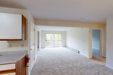 Located at Olde Orchard Park in South Burlington, Vermont, this 2-bedroom, 1-bathroom residence offers a well-organized, single-floor layout designed for comfortable everyday living. The open-concept living and dining area is generously sized, featuring neutral-toned carpet, warm beige walls, and a sliding glass door that floods the space with natural light and provides direct access to a private balcony with outdoor views of the surrounding greenery. Baseboard heating runs throughout, ensuring year-round comfort.

The kitchen is efficiently laid out with a galley-style design, featuring white upper and lower cabinetry with warm wood accents, a stainless steel range, a dishwasher, and a double-basin sink with ample counter space. Tile flooring and a dedicated closet-style pantry add to the kitchen's functionality.

Both bedrooms are carpeted and bathed in natural light from well-positioned windows overlooking the lush tree line. The primary bedroom is spacious and includes a dedicated closet. The full bathroom features tile flooring, a single-sink vanity with wood-trimmed cabinetry, and a full tub-shower combination. An in-unit laundry area adds everyday convenience, rounding out this practical and inviting home.