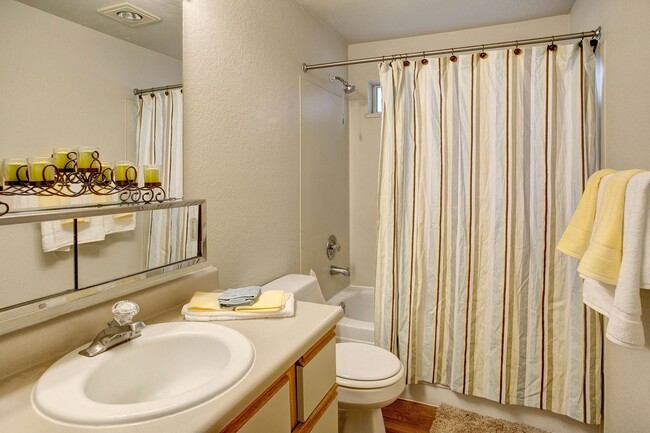 A bathroom with a shower and bathtub as well as storage above and below the sink - Heron View