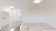 Located at 1235 W 66th St in Hialeah, Florida, this single-floor, one-bedroom, one-bathroom unit offers a well-organized layout across a compact but efficient footprint. Light-toned ceramic tile flooring runs consistently throughout every room, lending a clean and cohesive look to the entire space.

The kitchen is equipped with light wood cabinetry, a white electric range, a full-size refrigerator, and a stainless steel sink positioned beneath a window that brings in natural light. A partial counter divider separates the kitchen from the adjacent hallway area, providing a subtle distinction between spaces.

The bedroom is a bright, open room featuring a wall-mounted air conditioning unit and a window with blinds offering views of the surrounding greenery. A set of full-width louvered bifold closet doors provides ample built-in storage.

The bathroom is a standout with its retro-style turquoise tile lining the shower-tub surround, contrasting with the white floor tiles, toilet, and vanity. A window above the tub allows for natural ventilation and light.

A hallway connects the rooms, maintaining a logical and functional flow throughout the unit. The overall ambiance is clean, bright, and straightforward, making it a practical and low-maintenance living space.