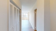 Located at 925 25th St NW in Washington, DC's West End neighborhood, this efficiently designed studio offers a well-organized single-floor layout encompassing a living area, kitchen, bathroom, and closet. The living area is bathed in natural light through a wide, multi-pane window that frames elevated views of the surrounding Washington cityscape, creating an open and airy atmosphere. Light-toned hardwood-style flooring runs throughout, lending the space a clean, modern aesthetic that complements the neutral white walls. The open-concept kitchen is seamlessly accessible from the main living area and features dark espresso cabinetry, stainless steel appliances including a range and microwave, and a pass-through counter that enhances the sense of connectivity. The bathroom is finished with crisp white subway tile in the tub/shower surround, chrome fixtures, and a granite-topped vanity, offering a polished and functional space. A dedicated closet provides practical storage within the compact footprint. The overall design prioritizes light, functionality, and clean lines, making it a well-appointed urban residence in one of DC's most accessible and vibrant neighborhoods.
